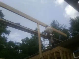 Carpenter setting a ridge beam over a new addition frame — Ice Dam Removal by Roofing Brothers in Sherrill