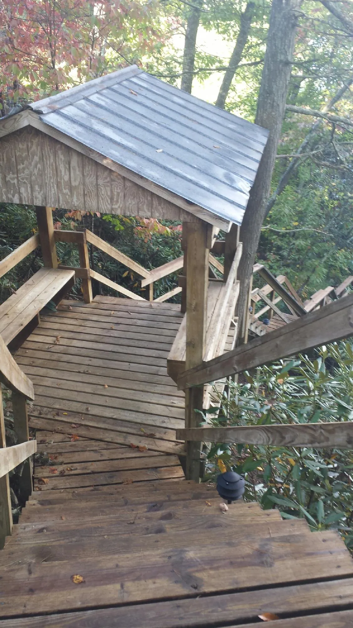 Metal roofed shelter over wooden steps on a wooded walkway — Skylight Repair & Installation work by our crew in Sherrill
