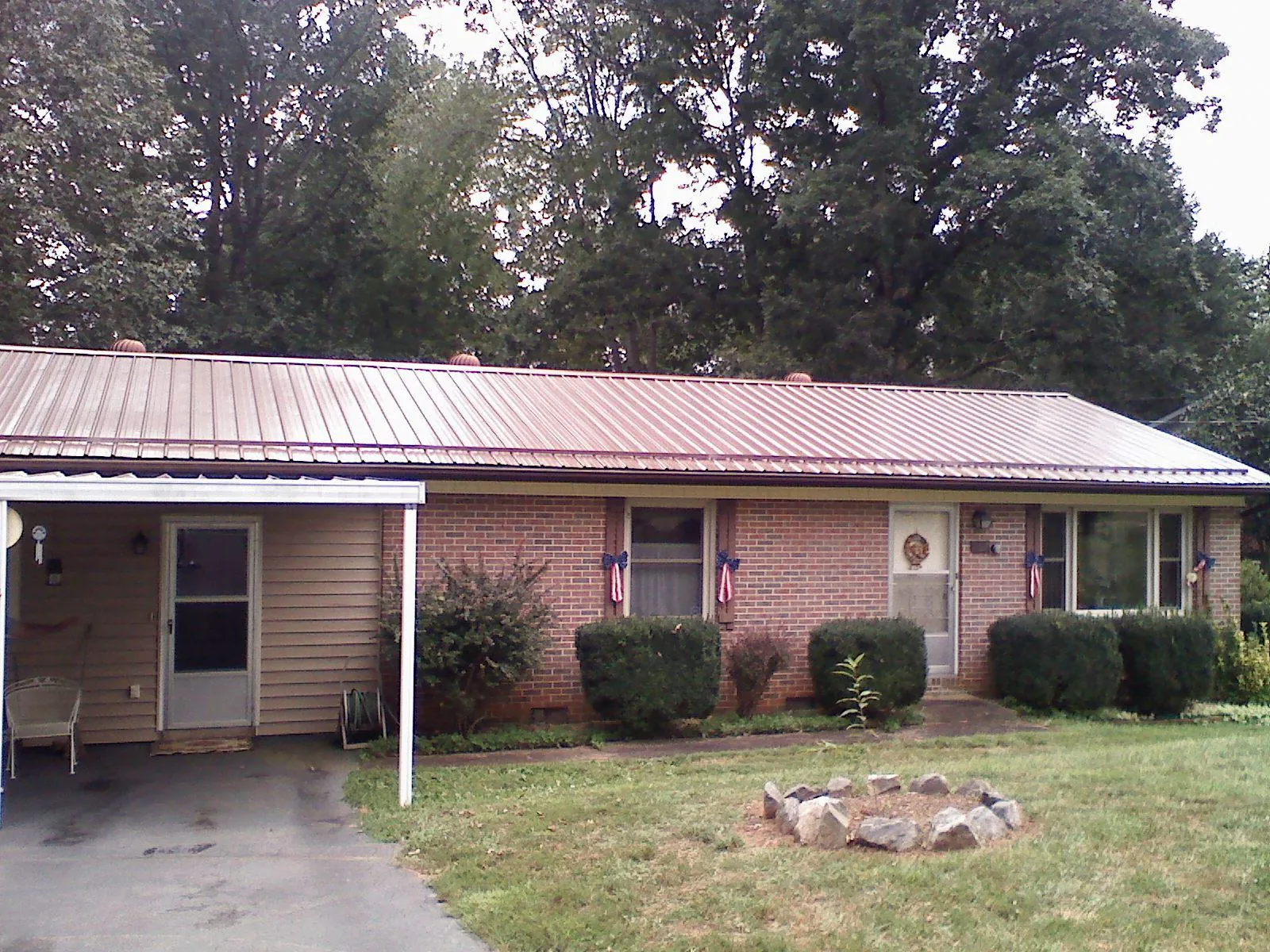 Bronze metal roof and carport on a brick ranch home — Roof Repair work by our crew in Sherrill